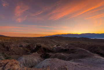 Fototapeta na wymiar Orange sky over the dry hills. Sanset at Artist's Drive, Death Valley National Park