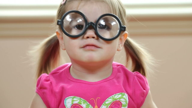 Young girl playing with silly glasses