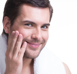 Obraz premium Smiling young man with hand near the face.