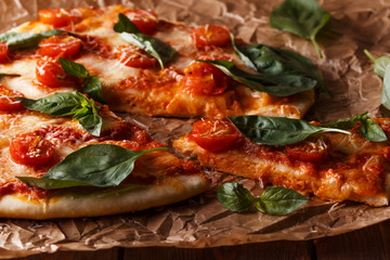 Homemade italian pizza with mozzarella, tomatoes and basil leave