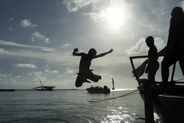 Children jumping in water from the boat in Zanzibar, Tanzania