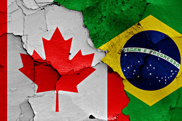 flags of Canada and Brazil painted on cracked wall