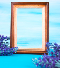 Wooden photo frame and lavender twig on a blue background
