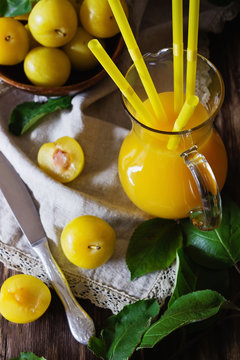 Yellow plum juice in a glass jug