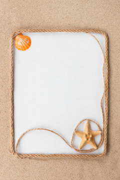 Beautiful frame of rope and star and sea shells with a white background on the sand
