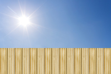 Wooden fence with blue sky and sun shines