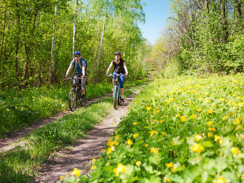 couple cycling in spring forest