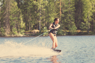Young woman study riding wakeboarding on a lake