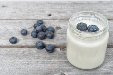 Homemade natural yogurt with blueberries fruits on a wooden tabl