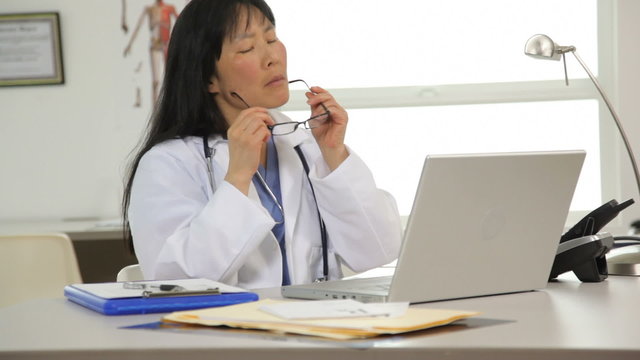 Doctor working at desk with laptop computer
