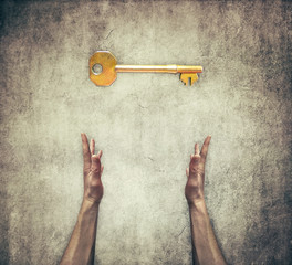 Closeup of two human hands offer a golden key to success. Turnkey solution and services concept