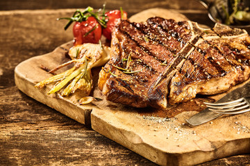 Cooked tbone steak with roasted garlic and tomato