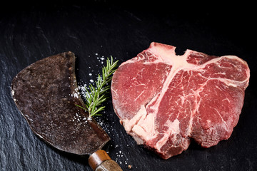 Vintage meat cleaver with a raw t-bone steak