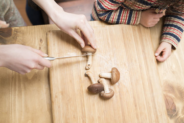 椎茸を切る母とそれを見る子供