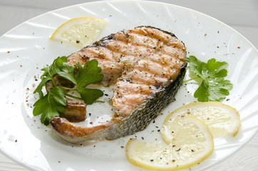 grilled salmon steak on  round white plate