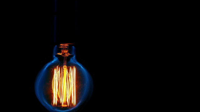 Light bulb flickering. Vintage filament Edison light bulb. Close up. 

