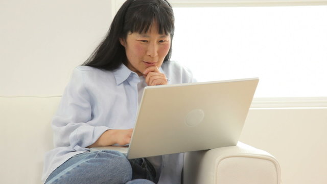 Mature Asian woman with laptop computer