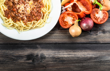 Cooked spaghetti bolognese and ingredients for cooking