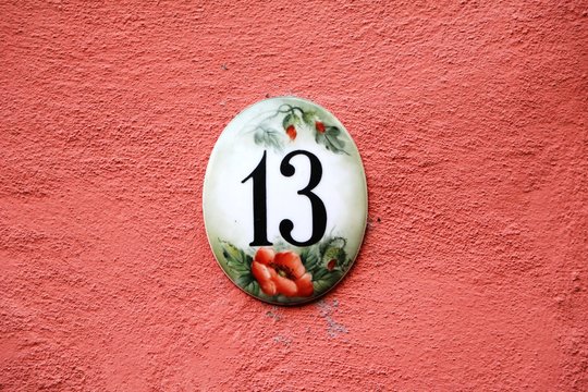 Number 13 at a red house wall