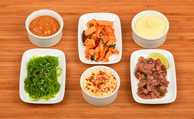 Three seafood salads with sauce on wood