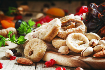 Delicious dried figs and dried fruit and nut mix on dark wooden