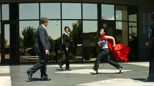 Businesswoman running with superhero cape, slow motion