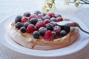 Pavlova meringue cake with cream and berries