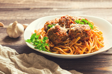 Linguine pasta with meatballs in tomato sauce and parsley