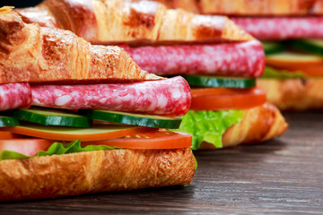 Fresh croissant with salami, chesse and vegetables. selected focus.