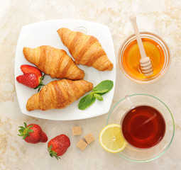 morning Breakfast - croissants with tea and honey. Spoon for hon