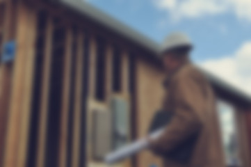 Blurred Construction Worker Inspecting Home Construction Site wi