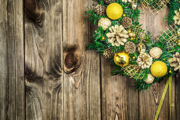 Christmas wreath on wooden door, decoration with ornaments on fir branches on rustic wood in brown