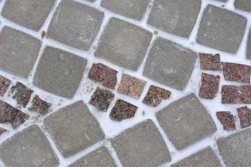 background of stone tiles on a track covered with snow