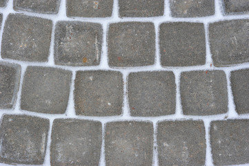 background of stone tiles on a track covered with snow
