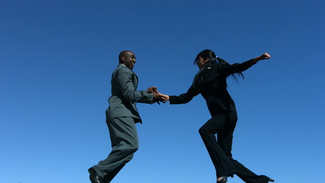Businesspeople shaking hands in mid-air, slow motion