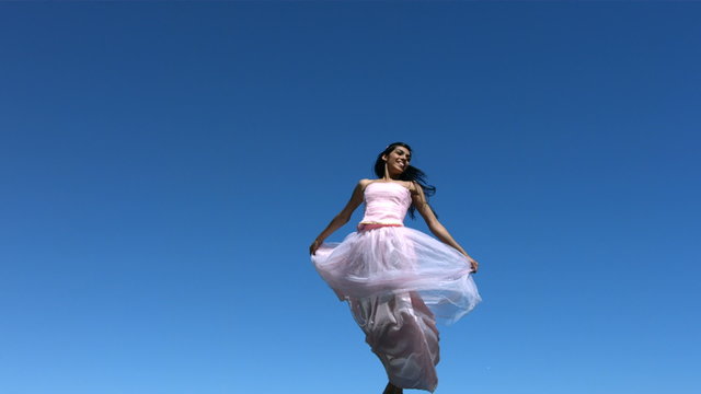Woman wearing dress jumps in air, slow motion