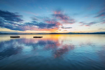 Stof per meter kleurrijke zonsondergangwolken bij blauw meer met houten plateaus in oostenrijk © A2LE