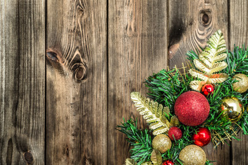 Christmas wreath on wooden door, decoration with ornaments on fir branches on rustic wood in brown
