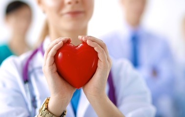 Female doctor with stethoscope holding heart