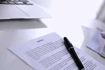 Obraz premium .Office workplace with a laptop and contract document on the light reflecting table