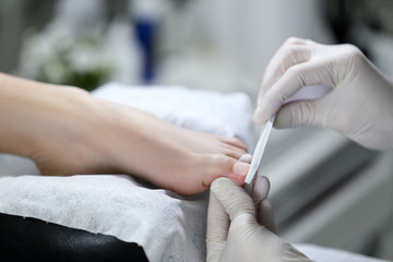 Close view of nails and feet with nail file. chiropody Master provides high quality services.