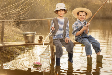 Boys fishes on a bridge on the lake