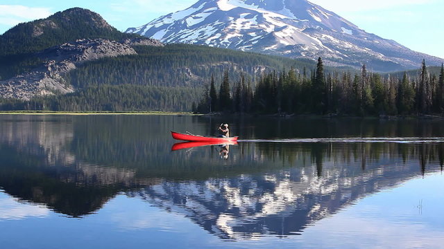 Man rowing canoe on lake