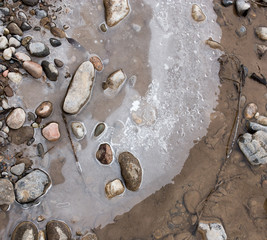 Fototapeta na wymiar Stones in the ice on the nature