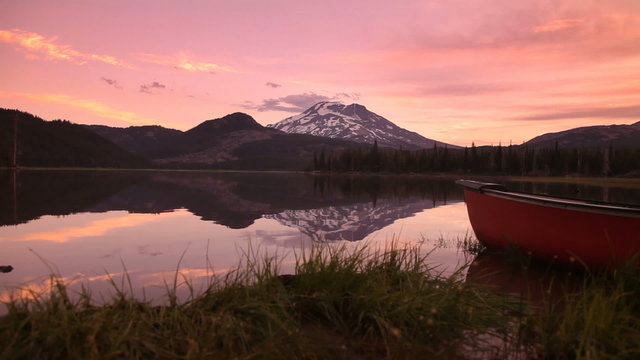 Canoe by lake at sunset