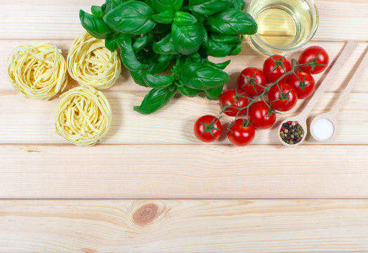 Raw homemade pasta and ingredients for pasta with tomatoes and basil.