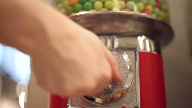 Girl pokes coin in machine sale of sweets, lends a hand and takes the sweets, in the mall

