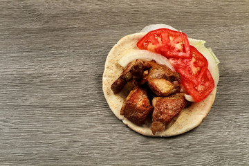 Greek souvlaki with pita bread and vegetables close-up on the table. Pork table