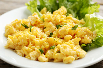 Scrambled eggs with vegetables on a grey wooden table