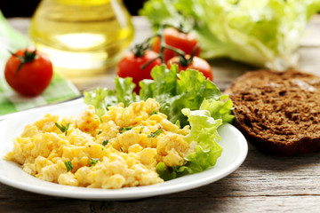 Scrambled eggs with vegetables on a grey wooden table